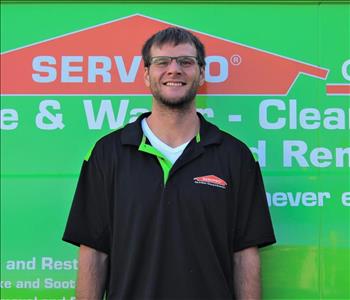 Man in SERVPRO uniform standing in front of a SERVPRO truck