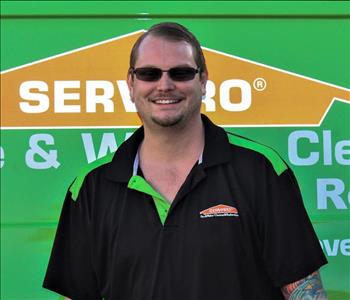 Man in SERVPRO uniform standing in front of a SERVPRO truck