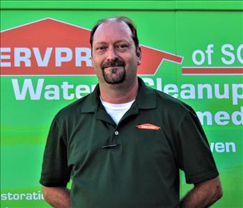 Man in SERVPRO uniform standing in front of a SERVPRO truck